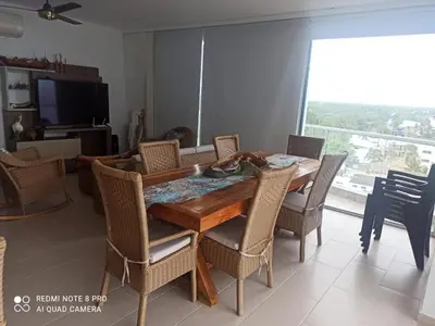 a dining room with a wooden table and chairs at Apartamentos Mi Reserva OK - Fontaine Bleu in Coveñas