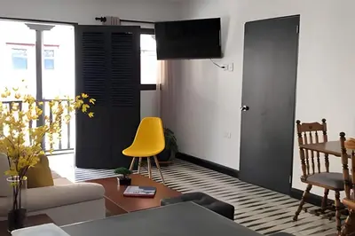 a living room with a yellow chair and a table at Céntrico y confortable apto Casa Doña Yola 11 in Cartagena de Indias