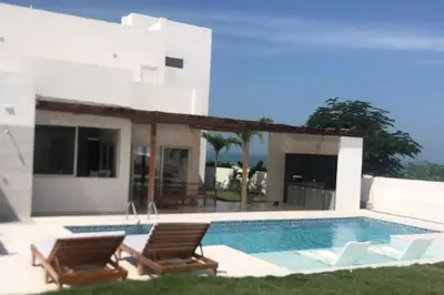 a swimming pool with two chairs and a house at Espectacular casa en oferta con piscina privada y vista al mar in Carretal