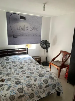 a bedroom with a bed and a lamp and a chair at Habitación Cangrejo in Barranquilla