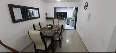 a dining room with a table and chairs and a kitchen at Habitación Cangrejo in Barranquilla