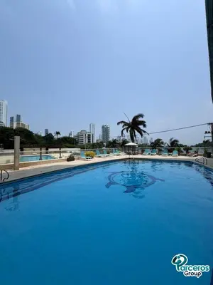 a large blue swimming pool with a palm tree in the background at Edificio Las Tres Carabelas Por Parceros Group in Cartagena de Indias
