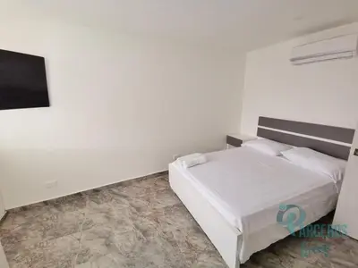 a white bedroom with a bed and a tv at Edificio Las Tres Carabelas Por Parceros Group in Cartagena de Indias