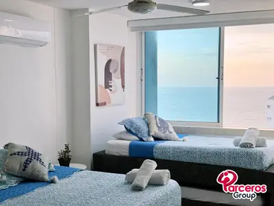 two beds in a room with a view of the ocean at Edificio Las Tres Carabelas Por Parceros Group in Cartagena de Indias