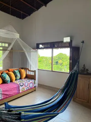 a bedroom with a bed with a hammock in it at Casa Majanicho in Rincón