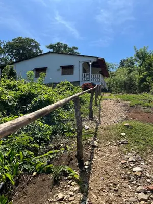a house with a fence next to a dirt road at Casa Majanicho in Rincón