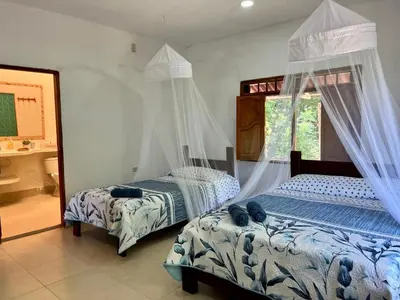 a bedroom with two beds and a window at Casa Majanicho in Rincón