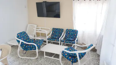 a group of chairs and a table and a tv at Cabaña La Pereztroica 2 in Puerto Viejo