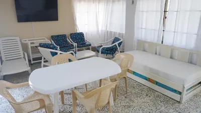 a room with two beds and chairs and tables at Cabaña La Pereztroica 2 in Puerto Viejo