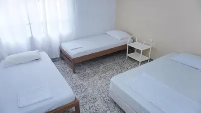 a room with two beds and a chair in it at Cabaña La Pereztroica 2 in Puerto Viejo