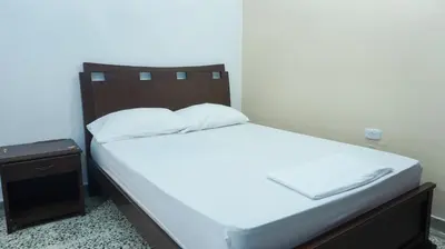 a bed with a wooden headboard in a room at Cabaña La Pereztroica 2 in Puerto Viejo