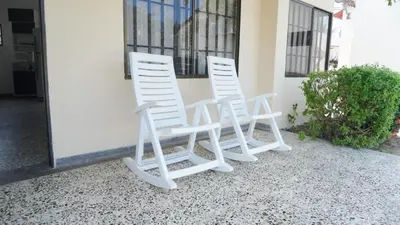 two white chairs sitting outside of a building at Cabaña La Pereztroica 1 in Coveñitas