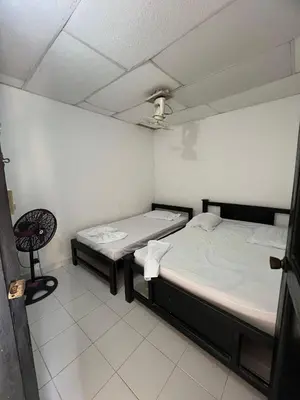 two twin beds in a room with a chair at Apartamentos Coveñas TII in Coveñas