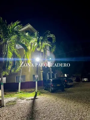 a building with palm trees in front of a parking lot at Apartamentos Coveñas TII in Coveñas