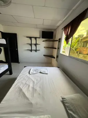 a bed in a room with a cross on the wall at Apartamentos Coveñas TII in Coveñas