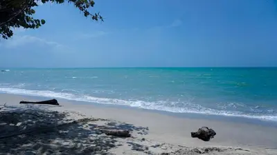 a beach with rocks in the sand and the ocean at Cabaña La Pereztroica 3 in Coveñitas