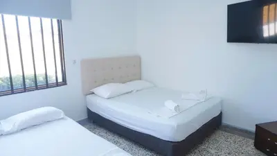 a hotel room with two beds and a flat screen tv at Cabaña La Pereztroica 3 in Coveñitas