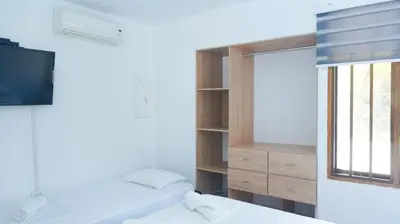 a bedroom with two beds and a tv and a window at Cabaña La Pereztroica 3 in Coveñitas