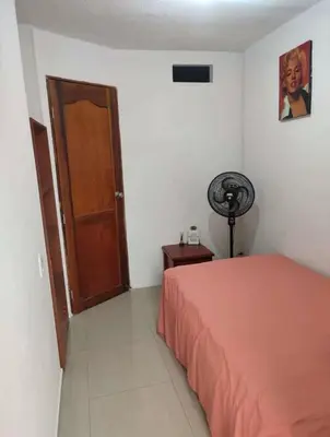 a bedroom with a bed and a wooden door at Habitación Estrella de Mar in Barranquilla
