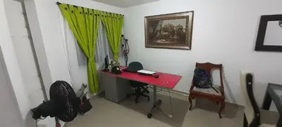 a room with a red desk and a green curtain at Habitación Estrella de Mar in Barranquilla