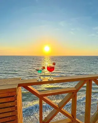 two martini glasses sitting on a table on the beach at SUITE OCEAN VIEW - Playa in Tolú