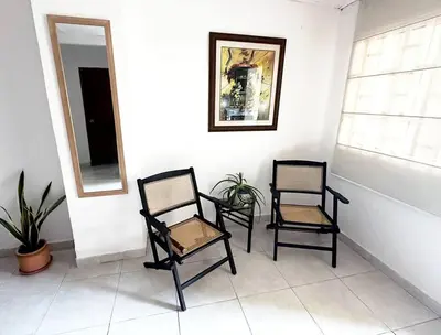 two black chairs sitting in a room with a mirror at Great Location, Apartment Close to the Malecón in Barranquilla