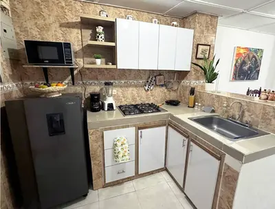 a kitchen with a black refrigerator and a sink at Great Location, Apartment Close to the Malecón in Barranquilla