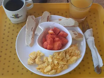 a plate of food with a bowl of fruit and toast at KAZA Balcones in Santa Veronica