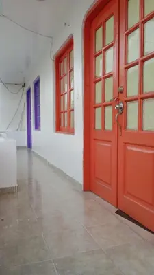 an empty room with a red door and windows at Hostal Miami Beach in Cartagena de Indias