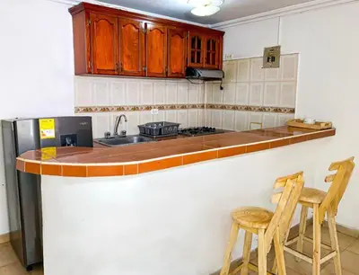 a kitchen with a counter with two chairs and a sink at Hostal Miami Beach in Cartagena de Indias