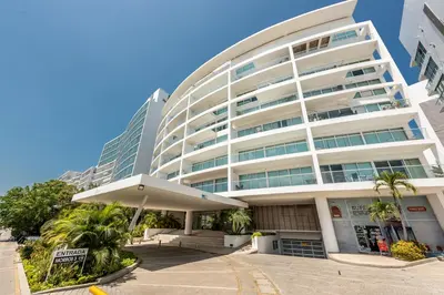 a large white building with palm trees in front of it at Edificio Morros 3 in Cartagena de Indias