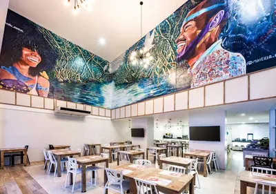 a restaurant with tables and a large mural on the wall at Holiday Inn Express - Cartagena Bocagrande by IHG in Cartagena de Indias