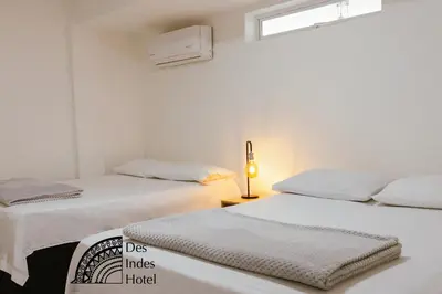 two beds in a white room with a window at DES INDES CARTAGENA in Cartagena de Indias