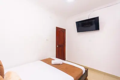 a bedroom with a bed and a tv on the wall at Hotel Med Cartagena in Cartagena de Indias