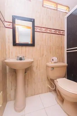 a bathroom with a toilet and a sink and a mirror at Hotel Med Cartagena in Cartagena de Indias