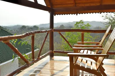 two chairs on a porch with a view of the mountains at Ecohotel Summer Usiacuri in Usiacurí