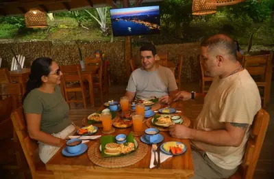a group of people sitting around a table eating food at Ecohotel Summer Usiacuri in Usiacurí