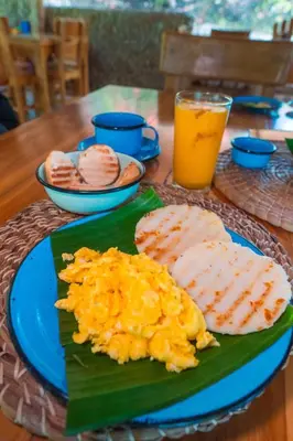 a table with a plate of food and a drink at Ecohotel Summer Usiacuri in Usiacurí