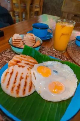 a plate with two eggs on top of a banana leaf at Ecohotel Summer Usiacuri in Usiacurí