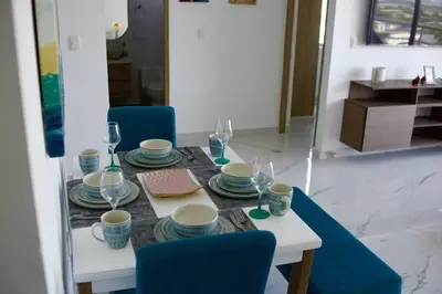 a table with plates and wine glasses on it at Great location close to airport in Cartagena de Indias