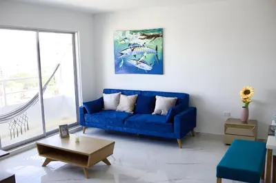 a blue couch in a living room with a window at Great location close to airport in Cartagena de Indias