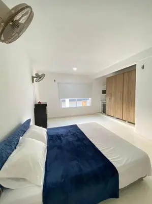a bedroom with a large bed with a blue blanket at Palma House - Cabaña con piscina in Tubará