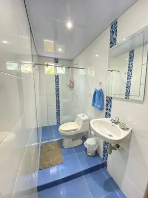 a bathroom with a white toilet and a sink at Palma House - Cabaña con piscina in Tubará