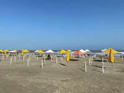 a group of umbrellas and chairs on a beach at Apartamento frente al Mar Cartagena in Cartagena de Indias