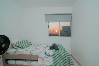 a bedroom with a bed and a window with a phone at Apartamento El Colibri CARTAGENA en TORRE PRIMI in Cartagena de Indias