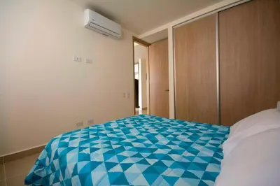 a bedroom with a blue and white bed and a closet at Exclusivo apartamento en Cielo Mar-playa las Americas, con maravillosas vistas del atardecer de Cartagena in Cartagena de Indias