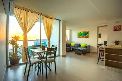 a living room with a table and chairs and a couch at Exclusivo apartamento en Cielo Mar-playa las Americas, con maravillosas vistas del atardecer de Cartagena in Cartagena de Indias
