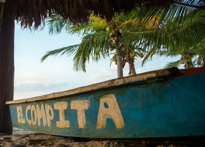 a sign on the beach with a palm tree in the background at Cabañas Privadas en Playas del Francés con Piscina in San Silvestre