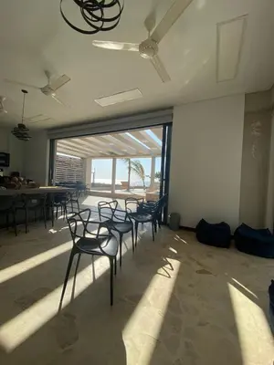 a group of chairs in a room with a large window at Cabañas Privadas en Playas del Francés con Piscina in San Silvestre