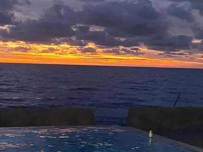 a sunset over the ocean with a swimming pool at Cabañas Privadas en Playas del Francés con Piscina in San Silvestre